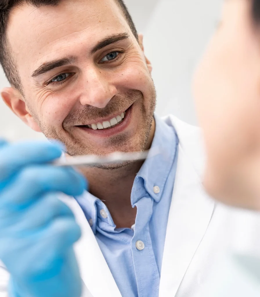 Zahnarzt lächelt, bei Untersuchung eines Patienten. Professionelle Zahnmedizin.