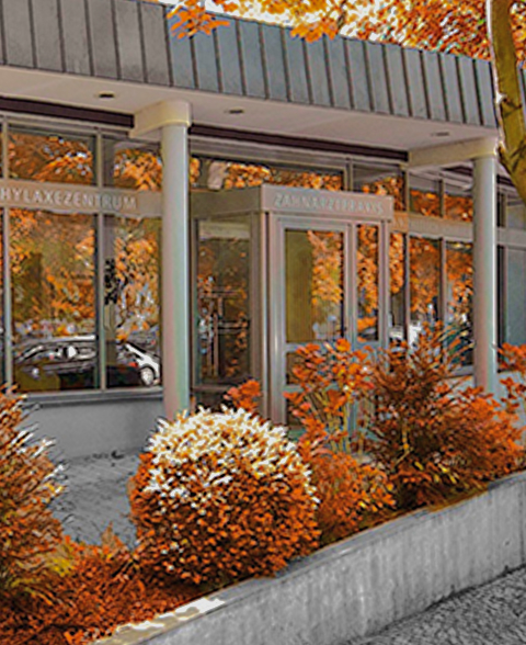 Moderne Zahnarztpraxis mit Herbstdekoration außen.