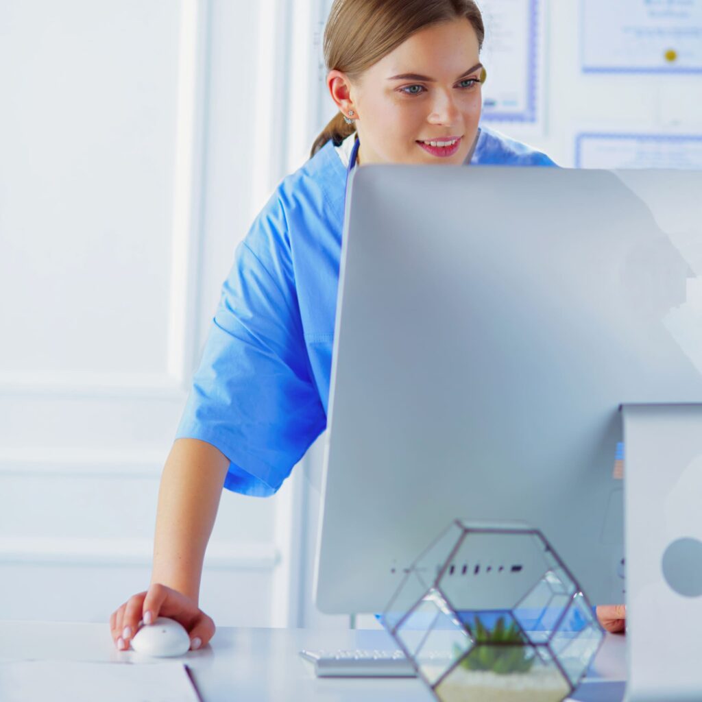 Zahnärztin bei der Büroarbeit am Computer im modernen Praxisbüro.