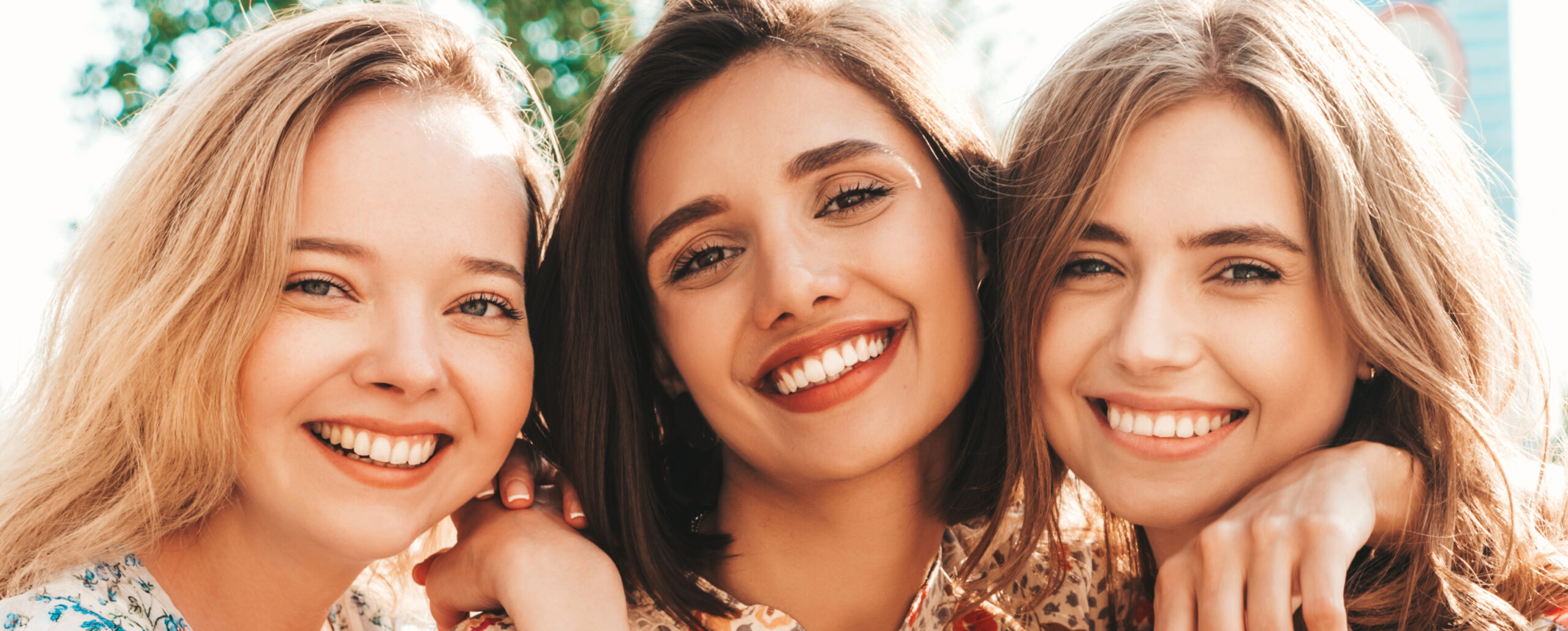 Lächelnde Frauen mit gesunden Zähnen, Symbol für erfolgreiche Zahnmedizin.