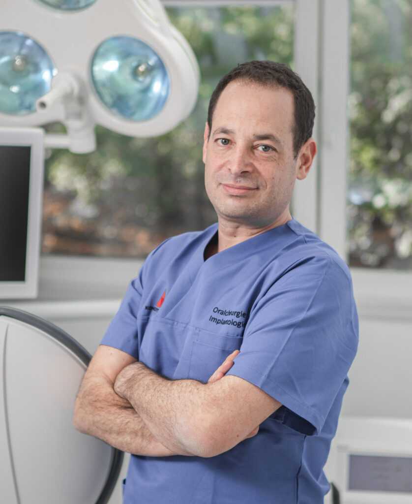 Zahnarzt in blauer Uniform im Behandlungsraum, professionelle Zahnmedizin.