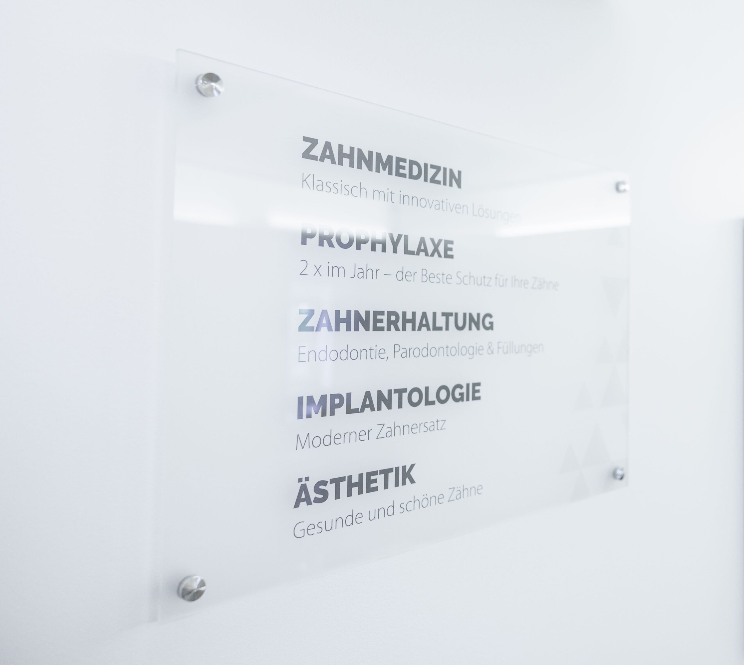 Praxisschild Zahnmedizin mit Behandlungen: Prophylaxe, Zahnerhaltung, Implantologie, Ästhetik.