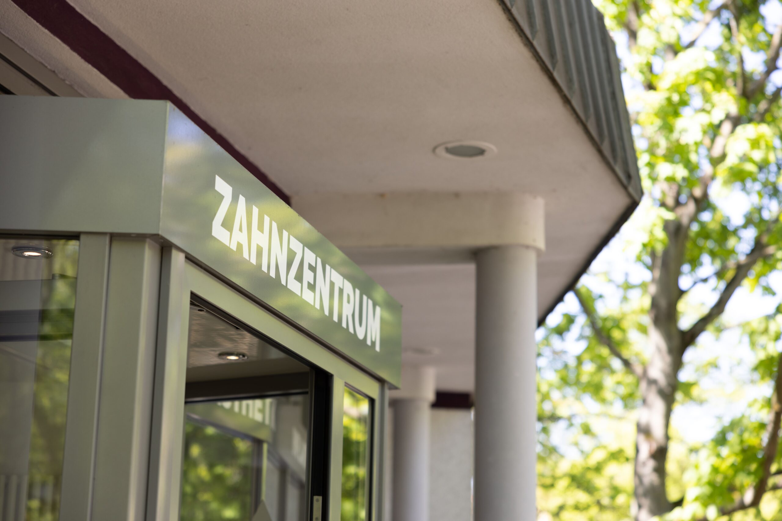Eingang eines Zahnzentrums mit moderner Beschilderung.
