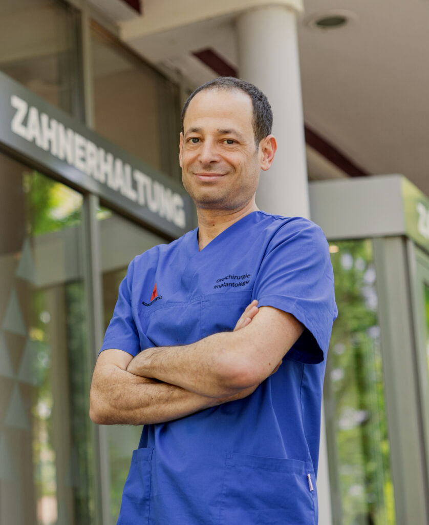 Zahnarzt in blauer Uniform vor Zahnerhaltungsklinik.