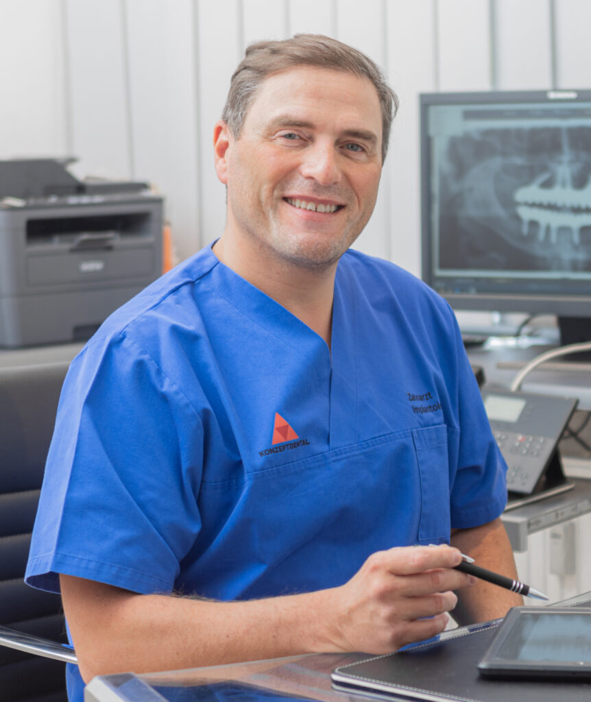 Zahnarzt in blauer Uniform vor Röntgenbild, fokussiert auf Implantologie und Oralchirurgie.