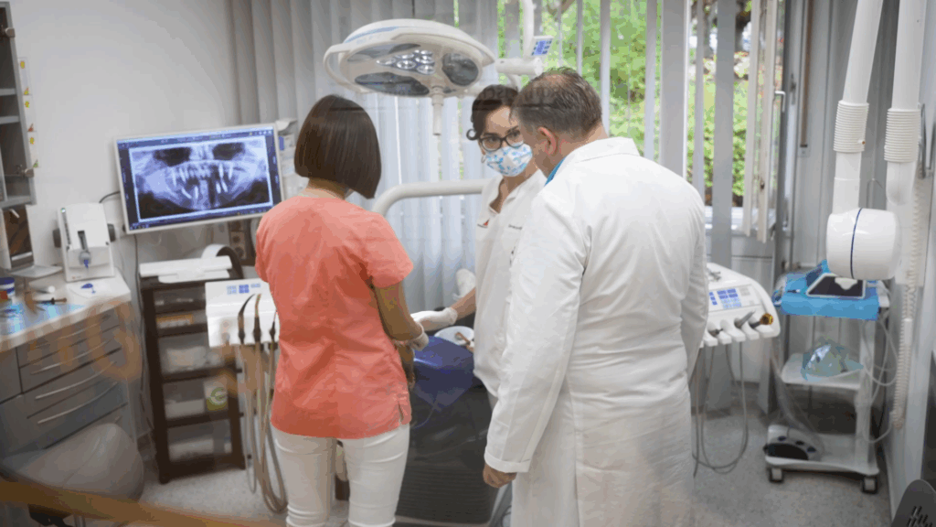Zahnärzte im Gespräch mit Patientin in moderner Zahnarztpraxis.