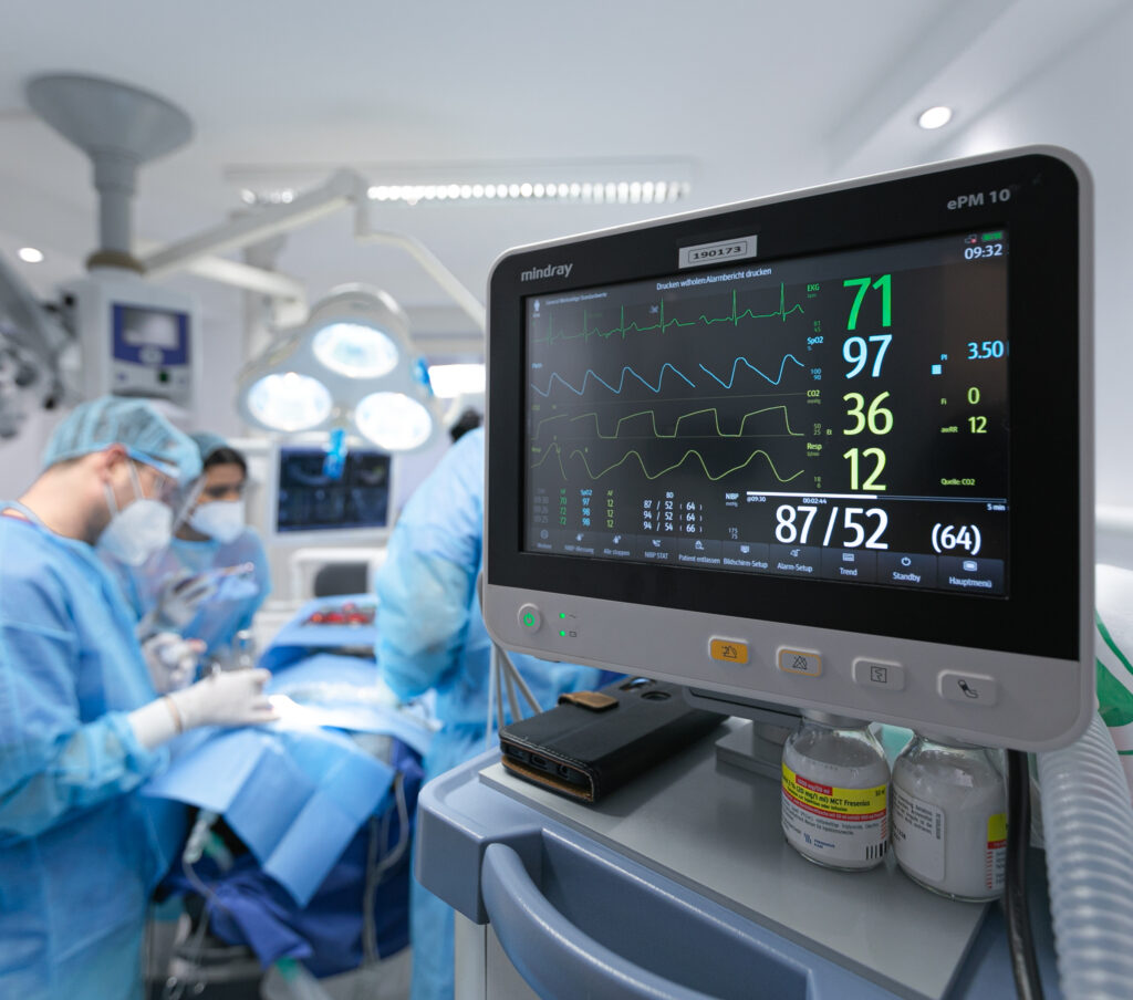 Zahnärztliche Operation mit Überwachungsmonitor im Vordergrund.