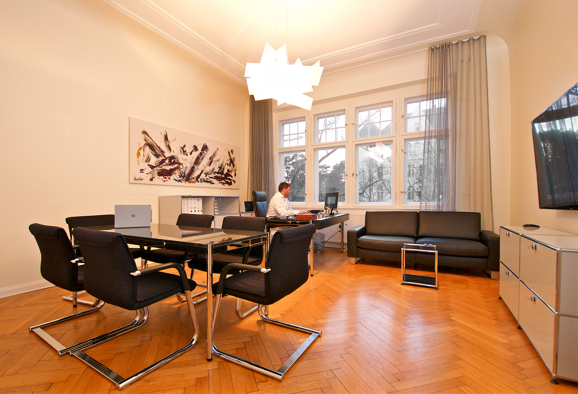 Moderne Zahnarztpraxis mit Schreibtisch und Konferenztisch, elegante Atmosphäre.