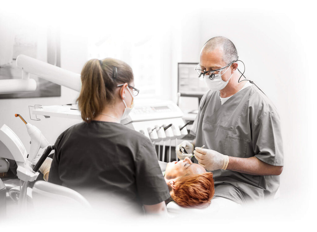 Zahnarzt und Assistentin behandeln Patienten in moderner Zahnarztpraxis.